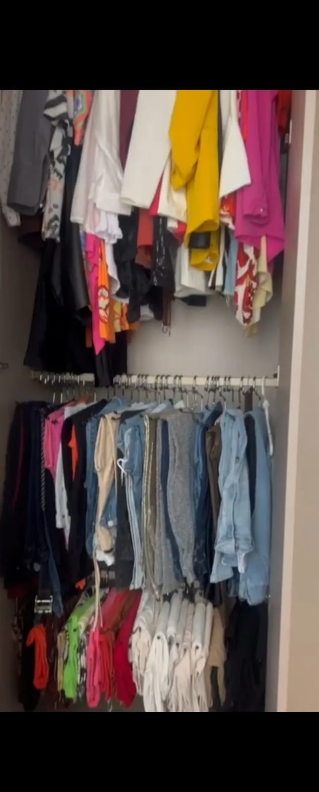 Guarda-roupa com peças penduradas e amontoadas, sem separação por tipo