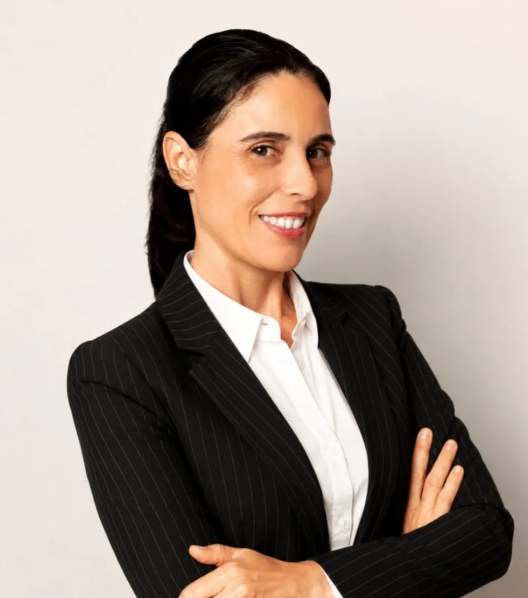 Retrato de Paty Costa sorrindo, de braços cruzados